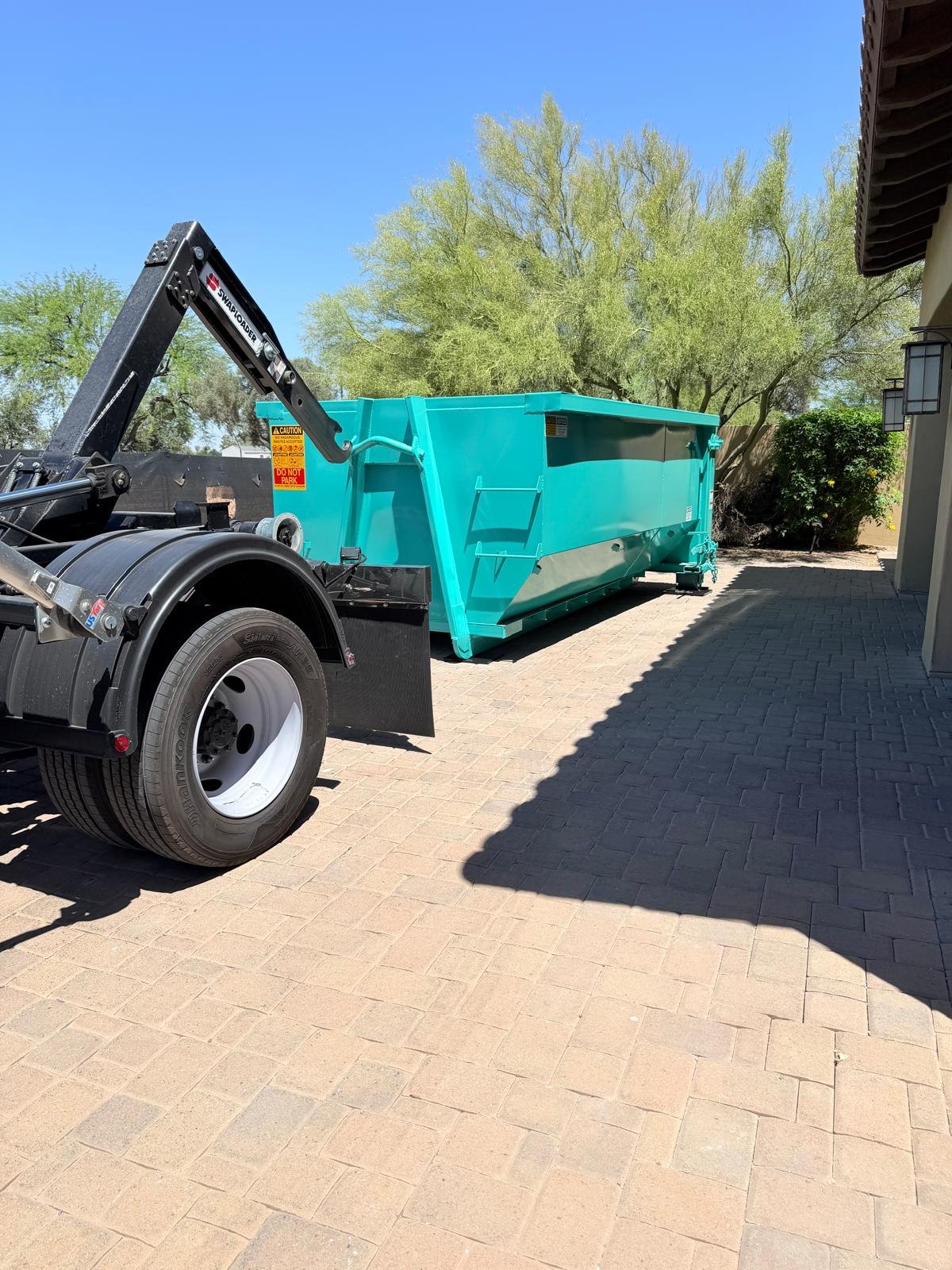 15-yard roll-off dumpster delivered to a paver driveway in Gilbert, AZ by East Valley Bin Co.